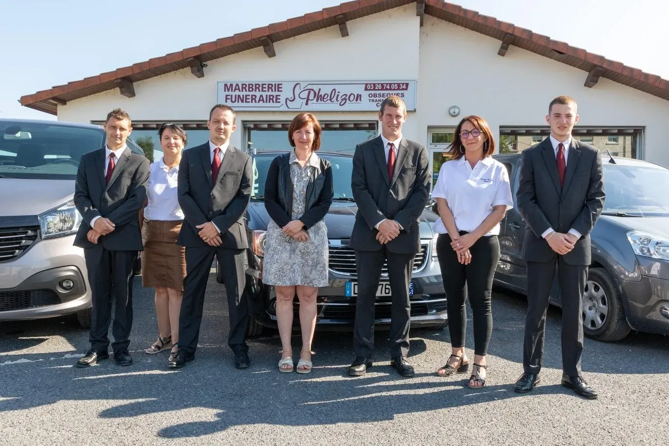 Équipe de conseillers et porteurs funèbres posant devant l'agence Phelizon.